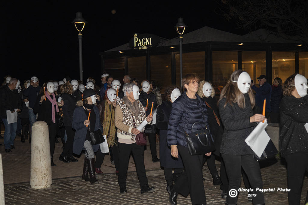 Una maschera bianca e una candela arancione: in piazza contro la violenza sulle donne